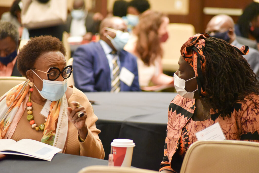 Two women talking, wearing protective masks